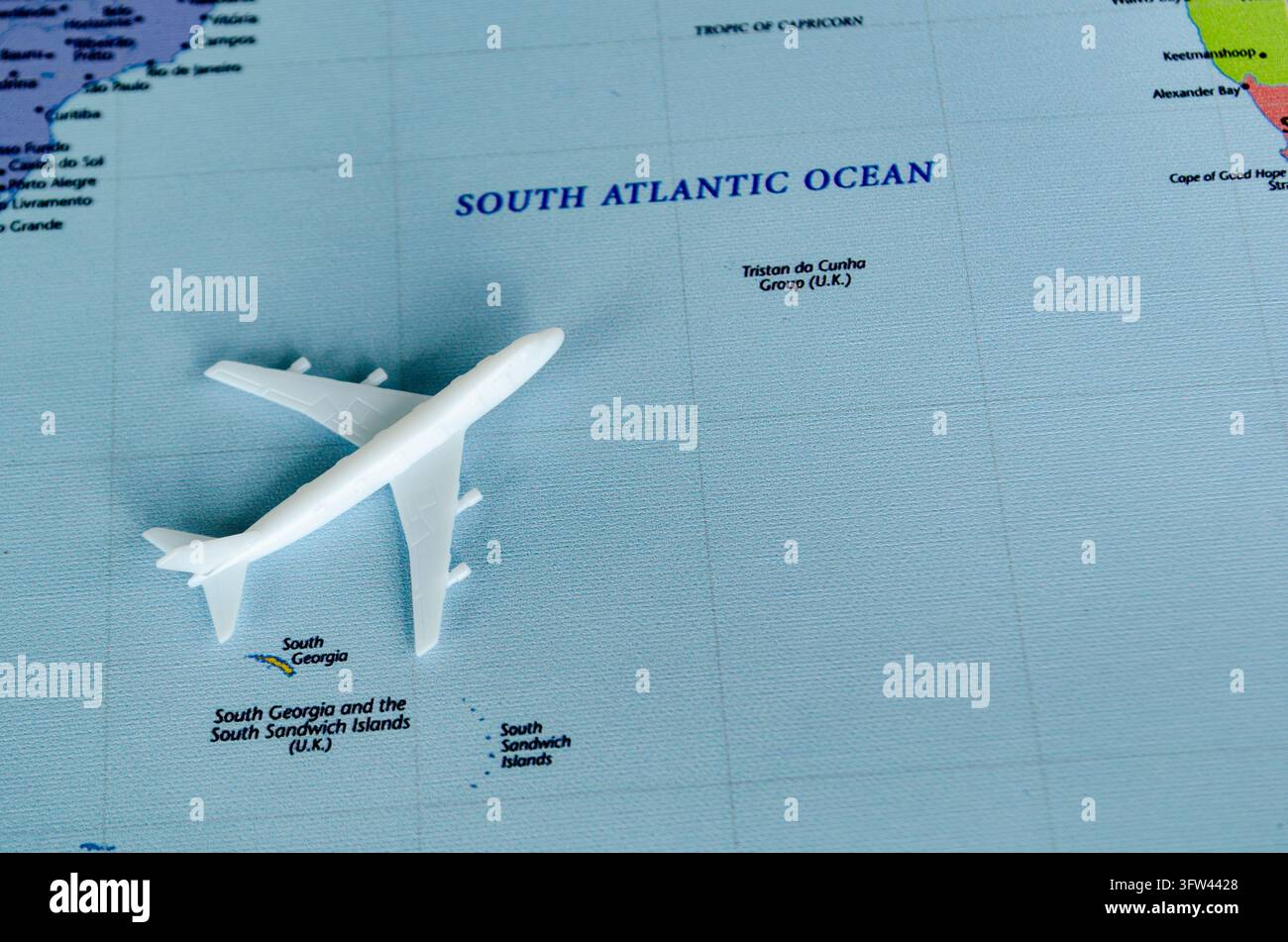 Miniatur-Jetflugzeug, das auf einem Weltkartenabschnitt des Südatlantiks platziert ist. Stockfoto