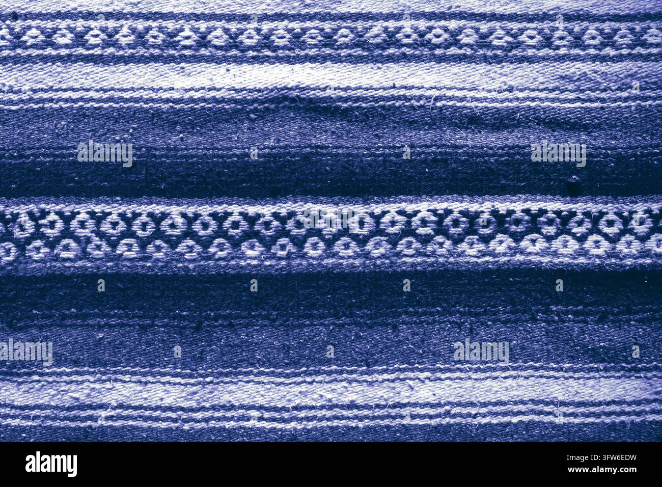 Handgefertigte gewebte grobe Flor blaue gemusterte Streuteppich-Hintergrundkulisse Stockfoto