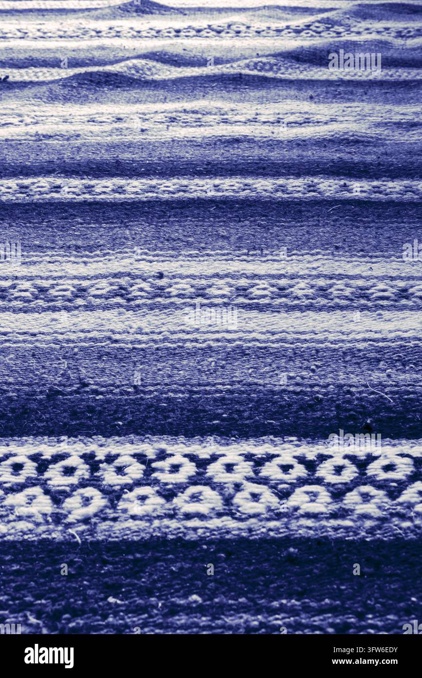 Handgefertigte gewebte grobe Flor blaue gemusterte Streuteppich-Hintergrundkulisse Stockfoto