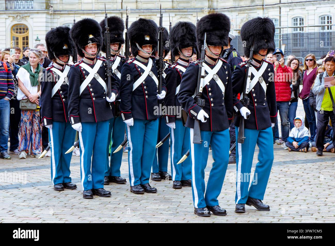Royal Life Guards (Den Kongelige Livgarde) in Bärenfellmützen und Ausgehuniform stehen in Formation im Amalienborg-Palast während des Wachwechsel Stockfoto