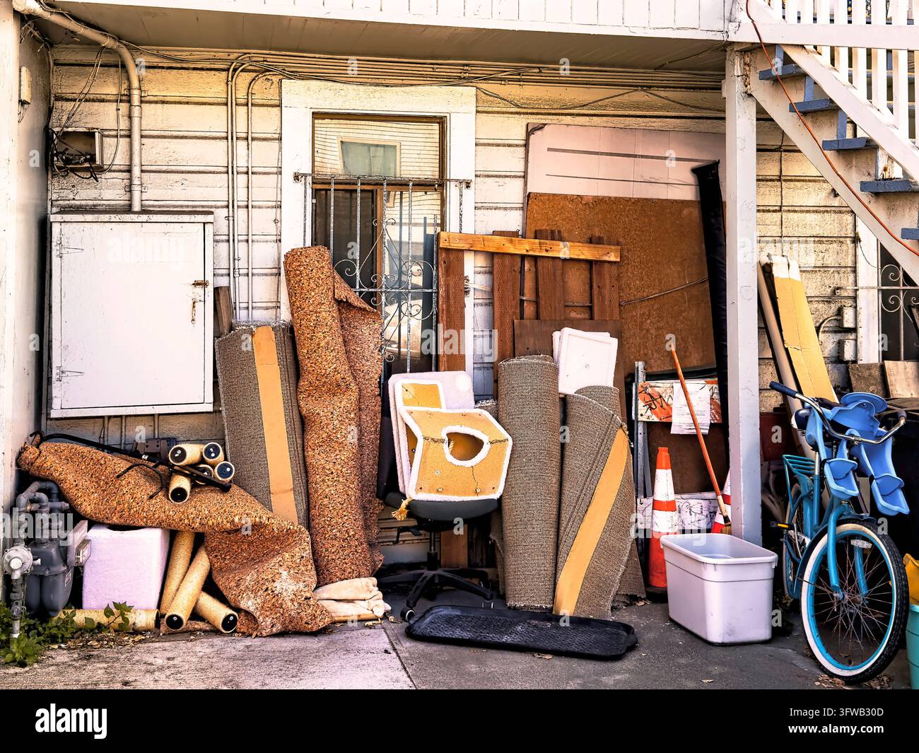 Altes Haus mit einem Haufen weggeworfener und verlassener Schrottstücke davor. Stockfoto