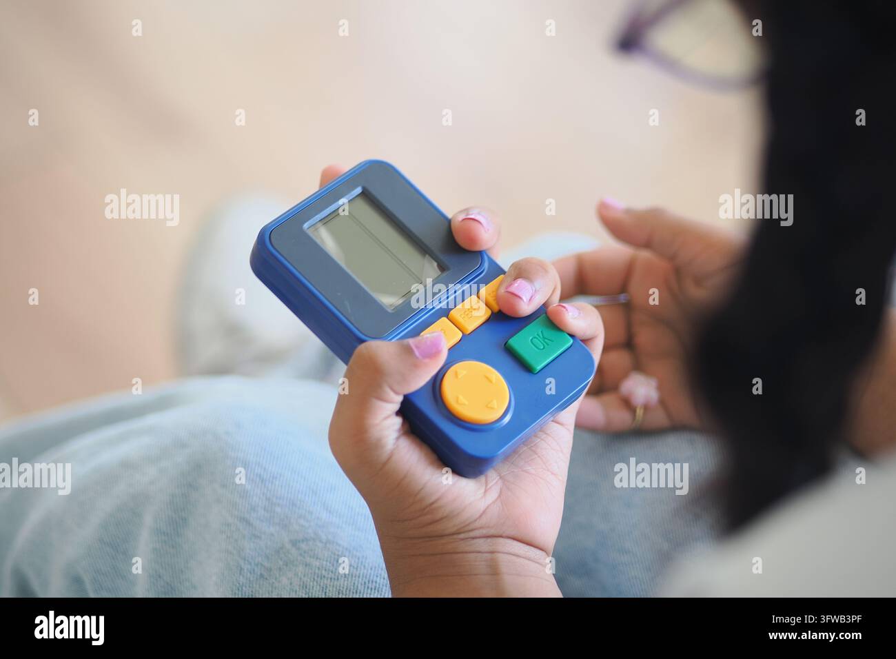 ein Kind, das ein Handheld-Retro-Arcade- und Spielgerät hält Stockfoto