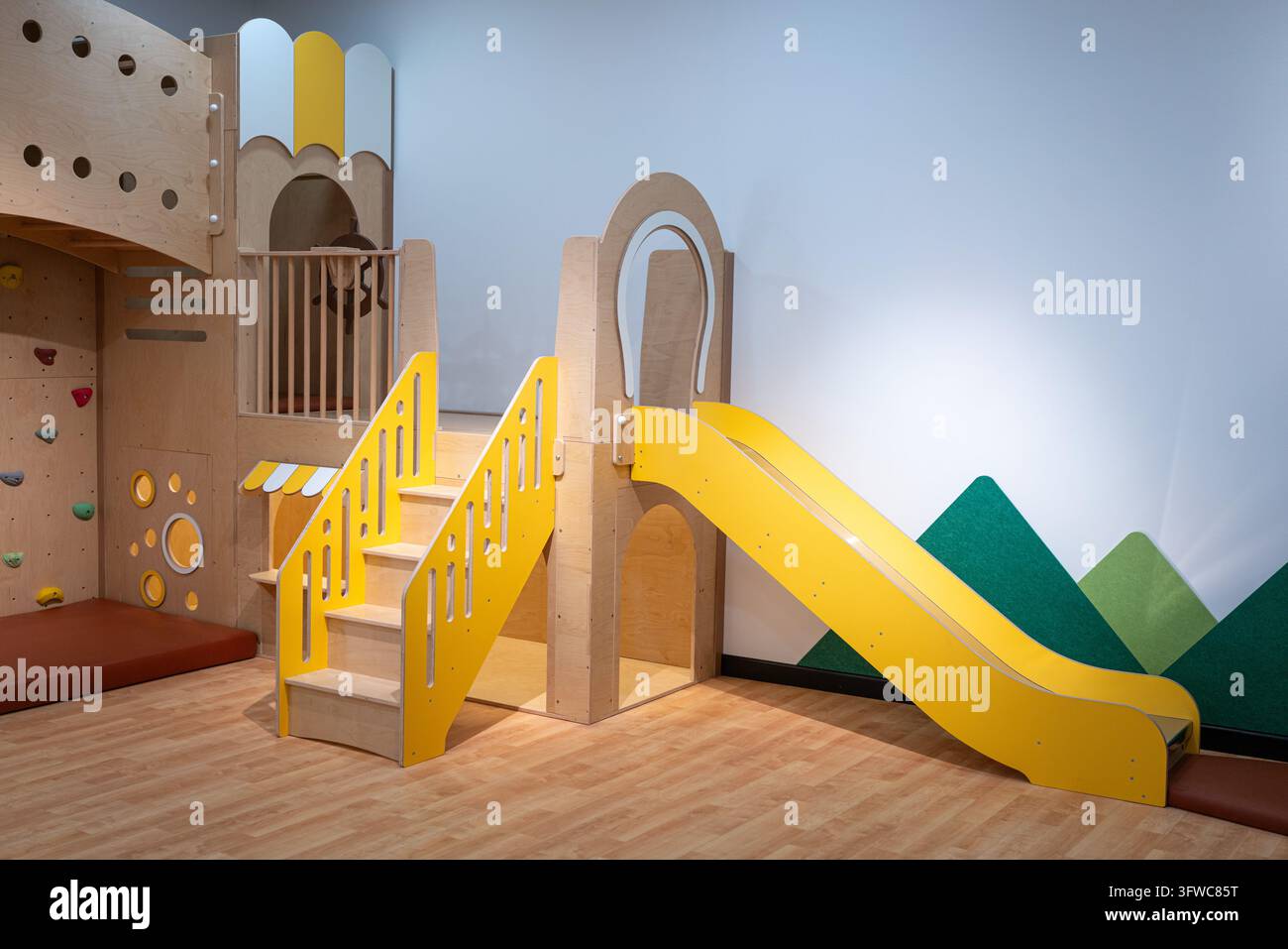 Farbenfroher Indoor-Kinderspielplatz mit Rutsche und Spielgeräten. Stockfoto