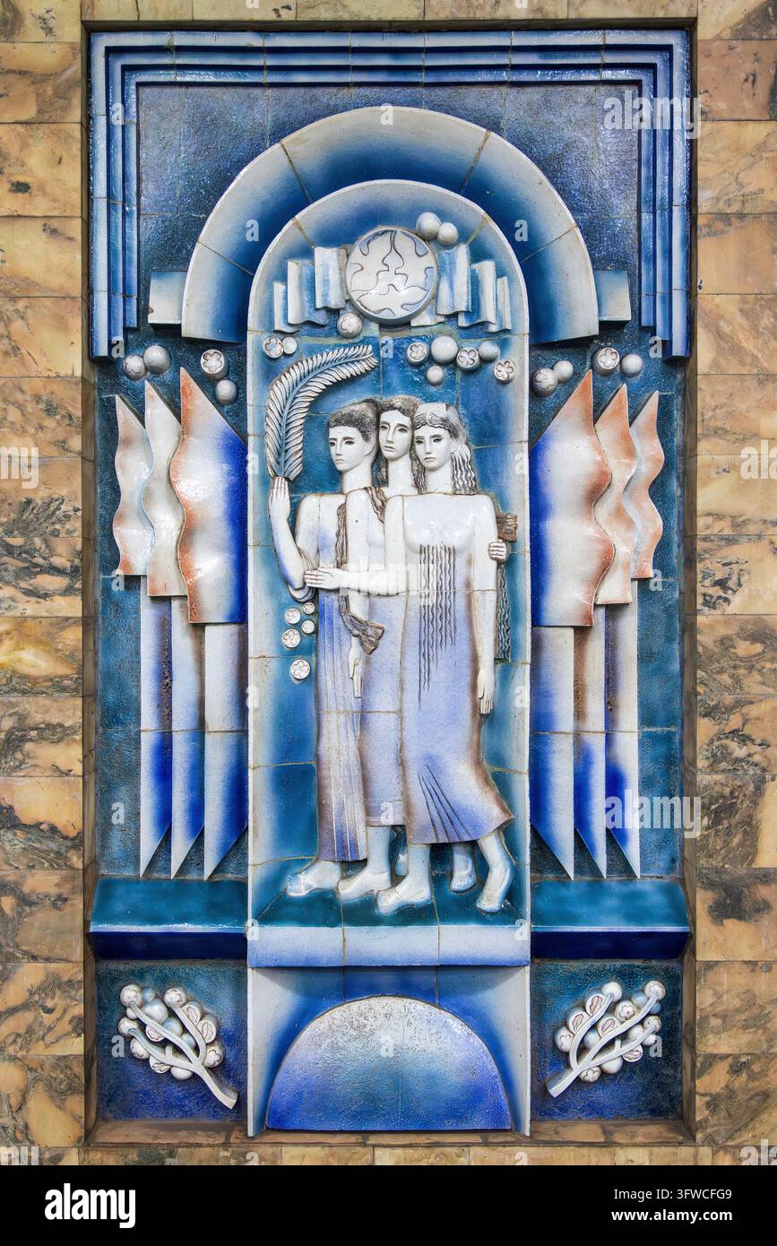 Dekoratives Basrelief-Mural in der Toshkent-Mural-Station, Taschkent, Usbekistan. Es zeigt drei Frauen und verschiedene Symbole des Friedens Stockfoto