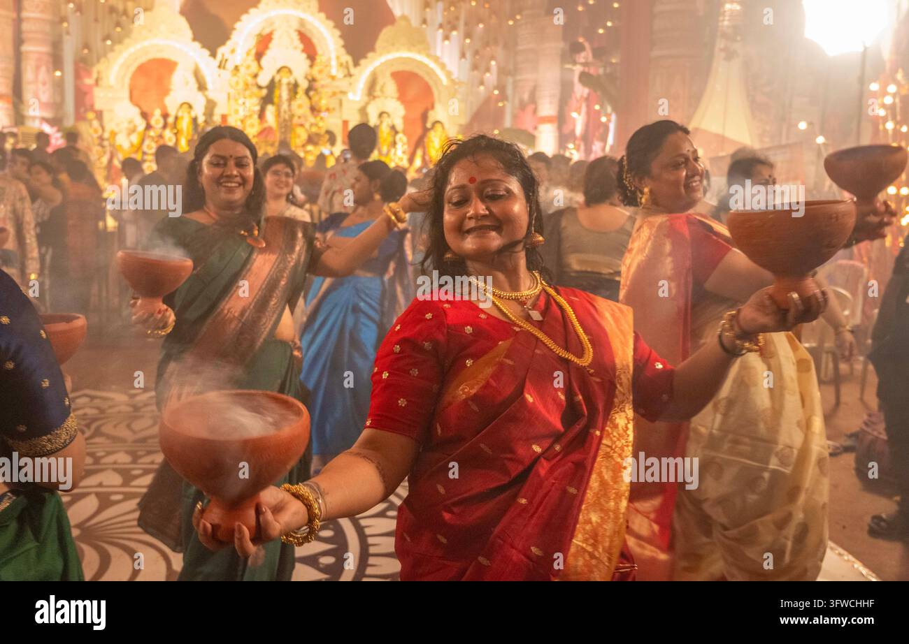 Neu-Delhi, Indien. 18. Oktober 2026. MUMBAI, INDIEN - 18. OKTOBER: Gläubige führen den Dhunuchi-Tanz (Dhunuchi Naach oder Dhunuchi Nritya) einen traditionellen bengalischen volkstümlichen Gottesdiensttanz während der abendlichen Aarti-Zeremonien bei der Durga Puja in Dadar, Shivaji Park, am 18. Oktober 2026 in Mumbai, Indien, auf. (Foto von Satish Bate/Hindustan Times/Sipa USA) Credit: Sipa USA/Alamy Live News Stockfoto