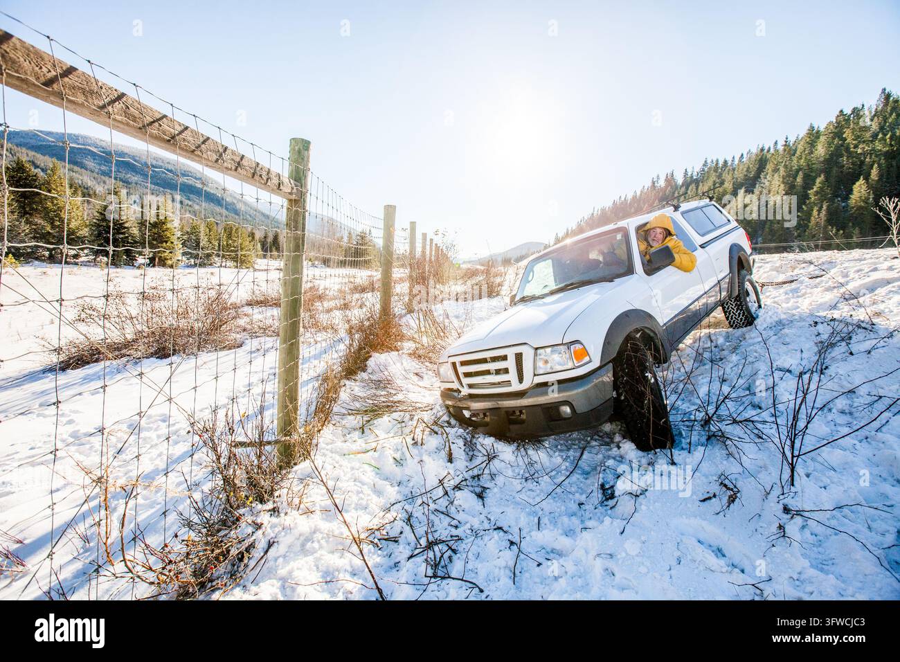 Mann genießt eine Geländefahrt in seinem Truck an einem verschneiten Tag Stockfoto