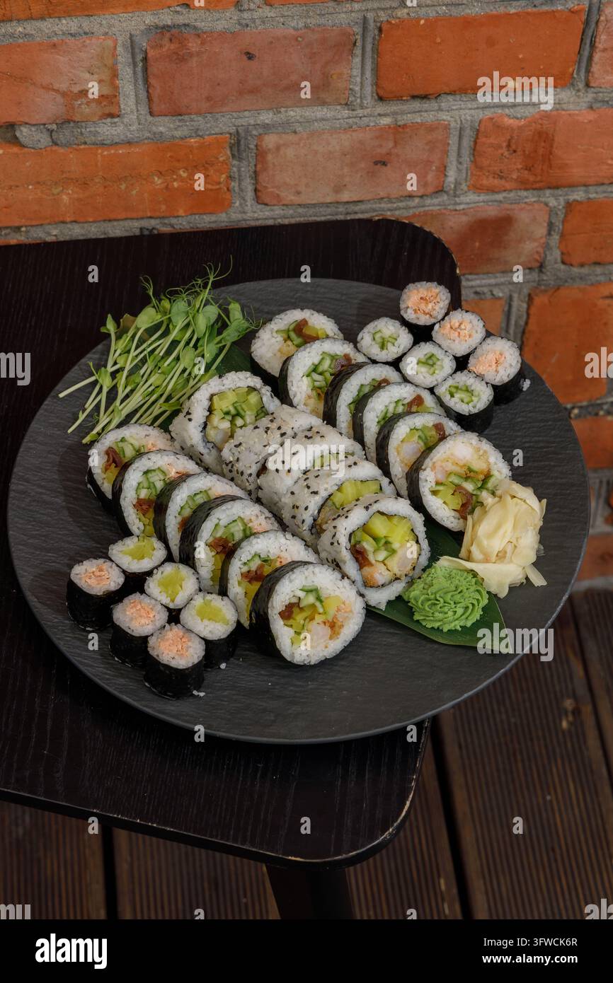 Sortiment frischer japanischer Sushi-Rollen auf einer Schieferplatte Stockfoto