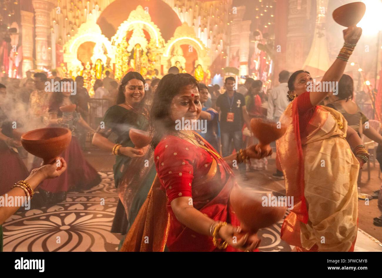 Neu-Delhi, Indien. 18. Oktober 2026. MUMBAI, INDIEN - 18. OKTOBER: Gläubige führen den Dhunuchi-Tanz (Dhunuchi Naach oder Dhunuchi Nritya) einen traditionellen bengalischen volkstümlichen Gottesdiensttanz während der abendlichen Aarti-Zeremonien bei der Durga Puja in Dadar, Shivaji Park, am 18. Oktober 2026 in Mumbai, Indien, auf. (Foto von Satish Bate/Hindustan Times/Sipa USA) Credit: Sipa USA/Alamy Live News Stockfoto