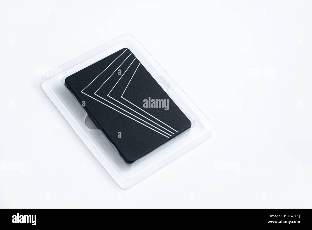 Eine brandneue schwarze Solid-State-Festplatte liegt in ihrer klaren Plastikverpackung auf einem schlichten weißen Hintergrund. Dieses Bild repräsentiert moderne Technologie und Daten Stockfoto
