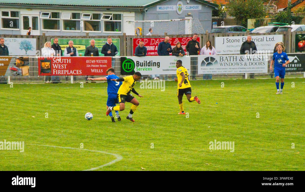Fußballspieler auf einem grünen Rasen. Ein Spieler in Gelb 11 und Blau 5 kämpfen um den Ball. Stockfoto