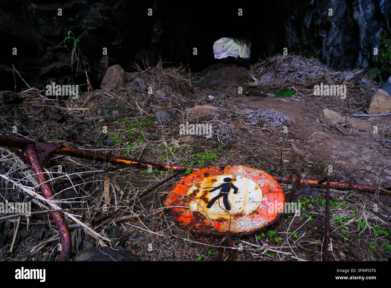 Eine Touristenroute entlang einer Höhle auf der Insel Madeira, Portugal, die durch ein Tor mit einem Hinweisschild „Kein Zutritt“ gesperrt ist. Stockfoto