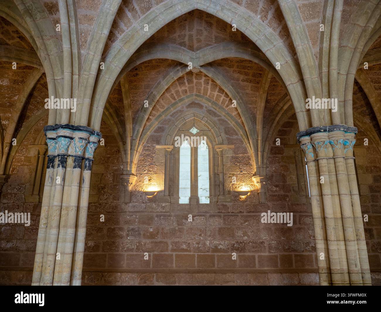 Gotische Bögen und gewölbte Deckeninterieur - Detaillierte Ansicht atemberaubender gotischer Architektur mit Rippengewölben, Steinbögen und einer wunderschön illuminierten Decke Stockfoto