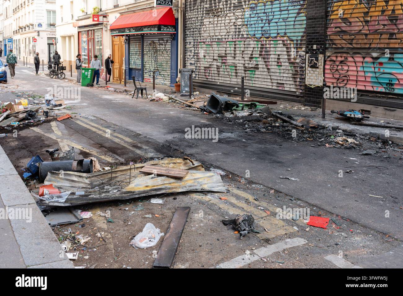 Eine Pariser Straße übersät mit verkohltem Schutt, beschädigten Armaturen und verbranntem Material nach einer Demonstration am Vortag. Stockfoto