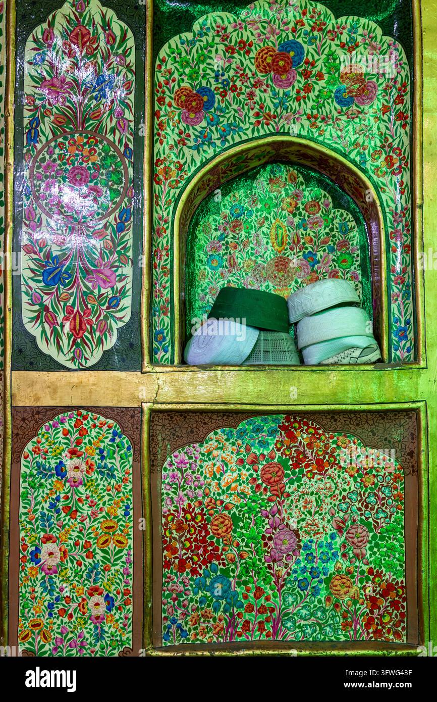 Gebetshüte in einer Nische einer mit Blumenmotiven bemalten Wand, Jammu und Kashmir, Srinagar, Indien Stockfoto