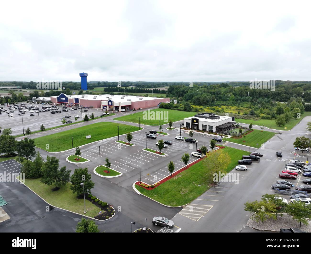 Luftbild eines Lowe's Baumarkts mit einem großen Parkplatz, umliegenden Grünflächen und einem blauen Wasserturm in der Ferne in Xenia, Oh Stockfoto