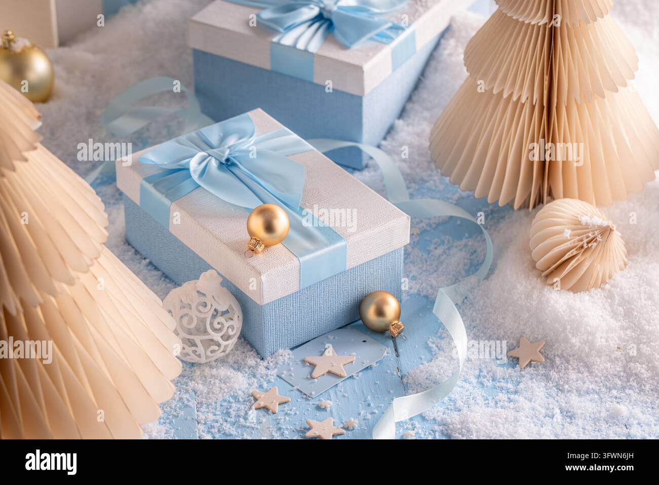 Blau verpacktes Paket, dekoriert mit blauen festlichen Schmuckstücken. Künstlerisches Thema für Weihnachtsgrußkarten. Stockfoto