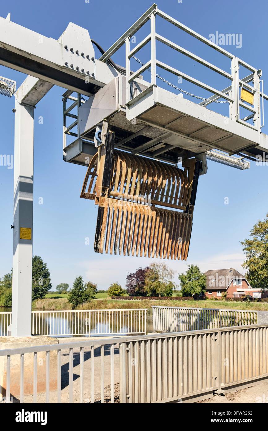 Varel, Deutschland – 2. September 2026: Mechanischer Schrottreinigungskran an der Vareler Pumpstation, Wasserwirtschafts- und Hochwasserschutzinfrastruktur, Industrieingenieurwesen für die Wasserwegewartung Stockfoto