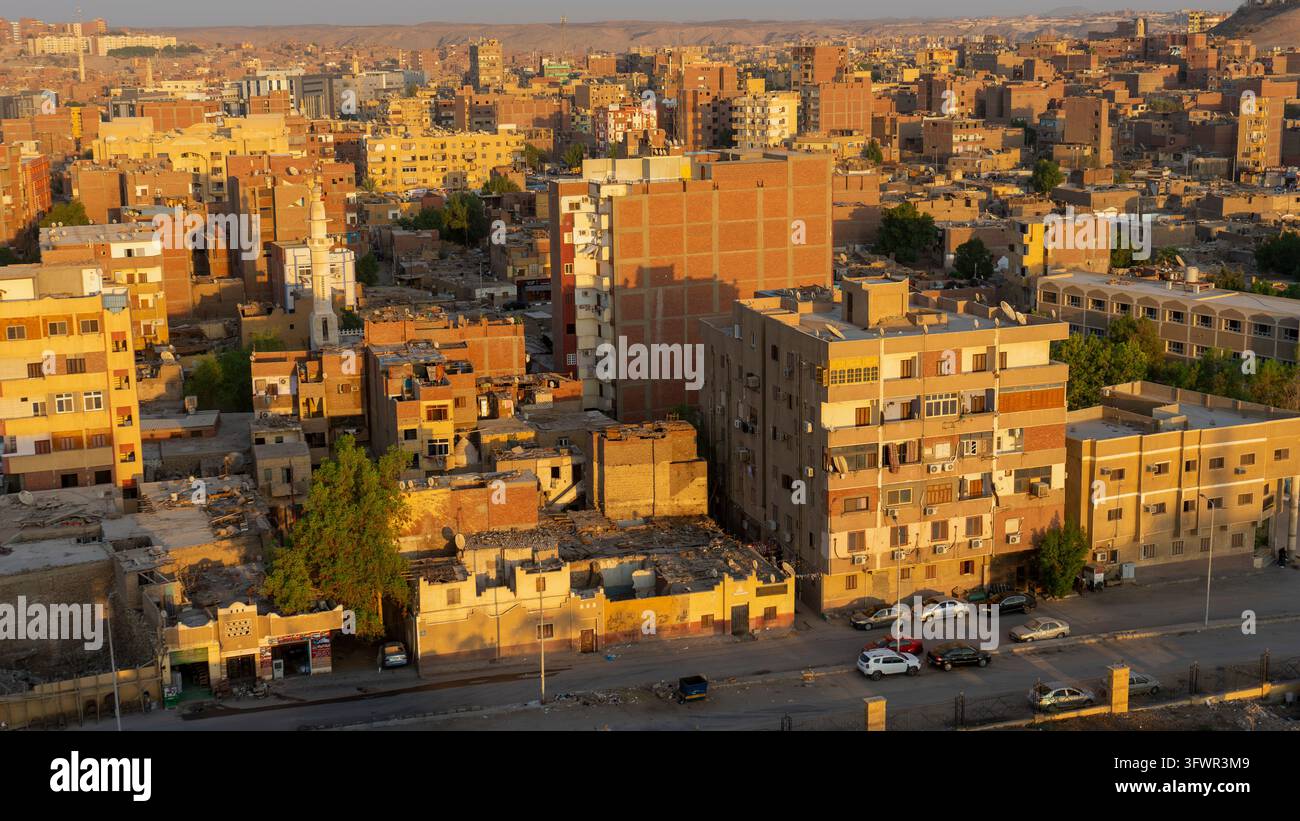 Panoramablick auf Aswan, Ägypten, der Wohnhäuser im traditionellen Baustil zeigt, die im goldenen Licht des Sonnenuntergangs baden Stockfoto