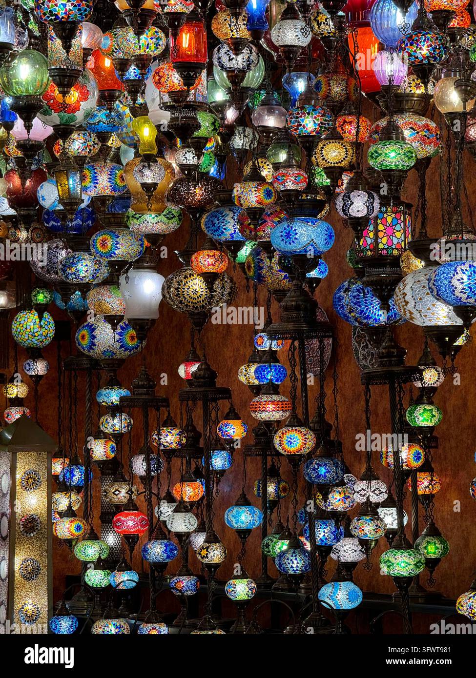 Bunte türkische Mosaik-Glaslampen, die im Großen Basar in Istanbul, Türkei, hängen - Smartphone-aufgenommenes Stockfoto