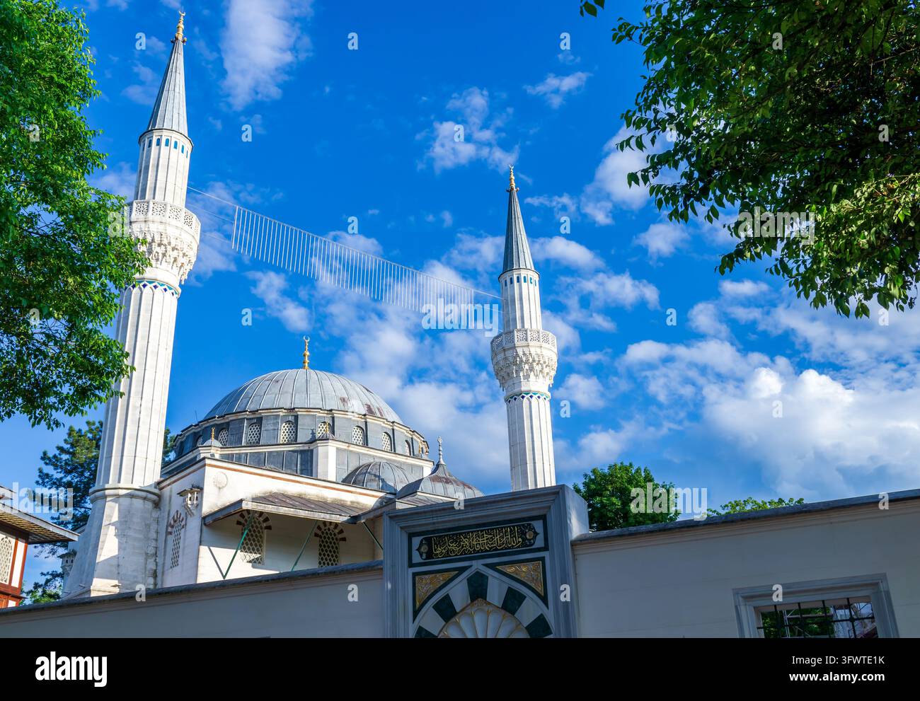 Die Kuppel und die beiden Minarette der Şehitlik-Moschee erheben sich über ihre Umfassungsmauer am Columbiadamm im Berliner Bezirk Neukölln, Deutschland. Sehitlik Moschee. Stockfoto