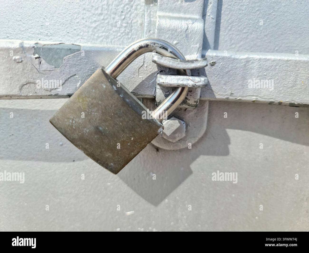 Schließen Sie ein Schloss an einer schließenden Metalltür Stockfoto