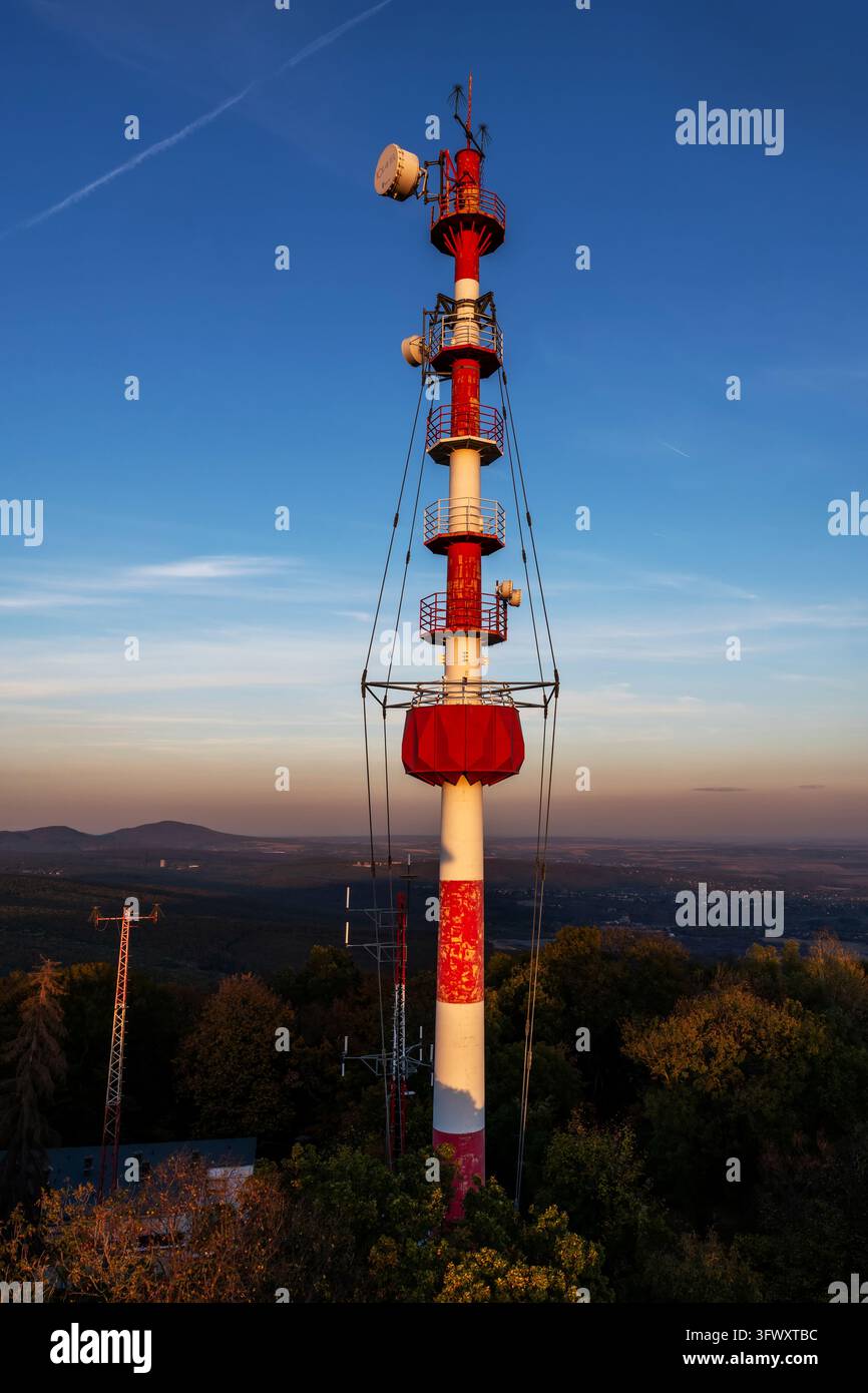 Hoher Kommunikationsturm, der von warmem Sonnenlicht beleuchtet wird Stockfoto