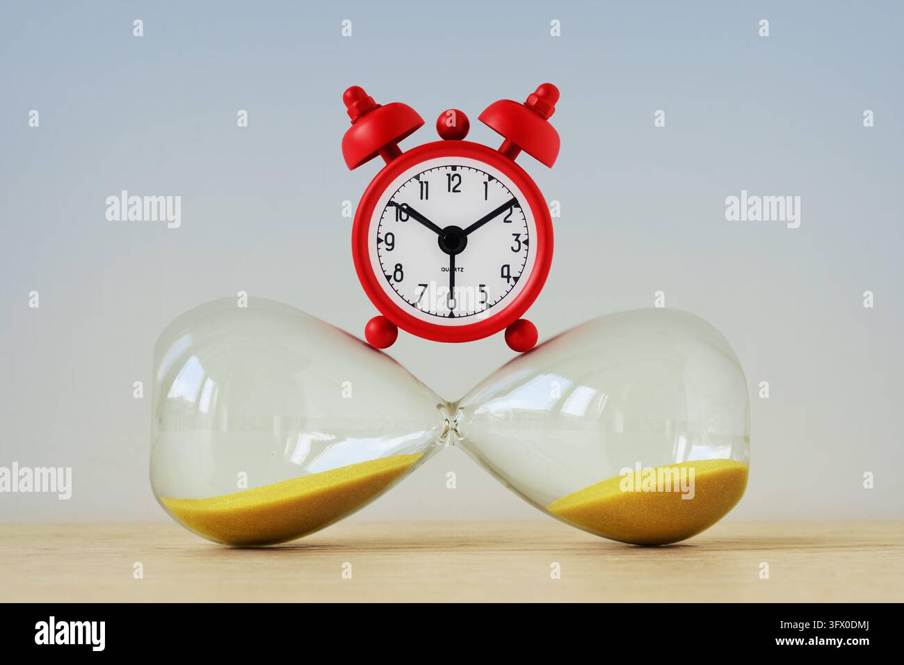 Wecker auf horizontaler Sanduhr - Konzept von Zeit und Frist Stockfoto