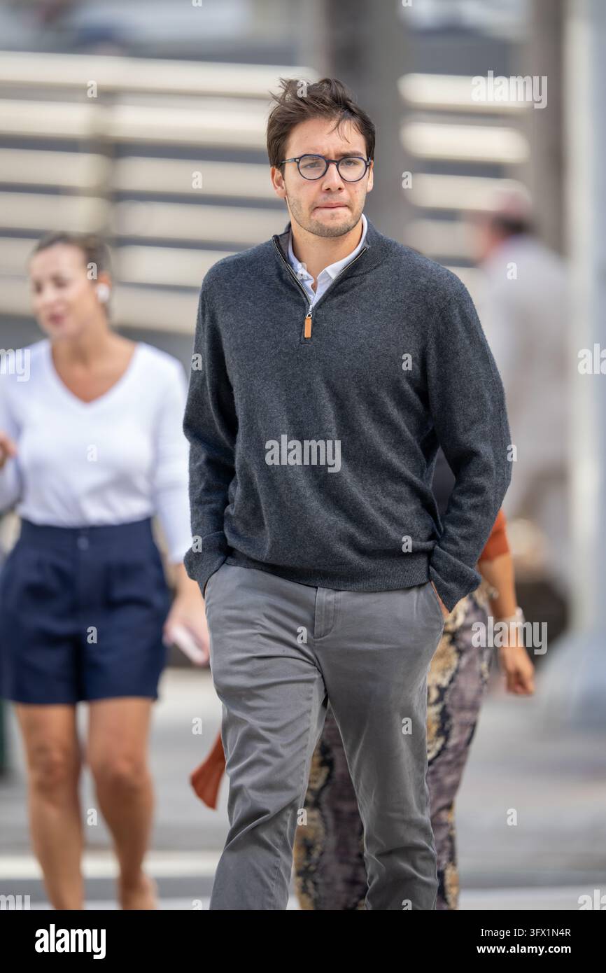 Brickell, FL, USA - 20. Oktober 2026: Junger Geschäftsmann überquert die Straße Brickell Avenue Miami und blickt von der Kamera weg Stockfoto