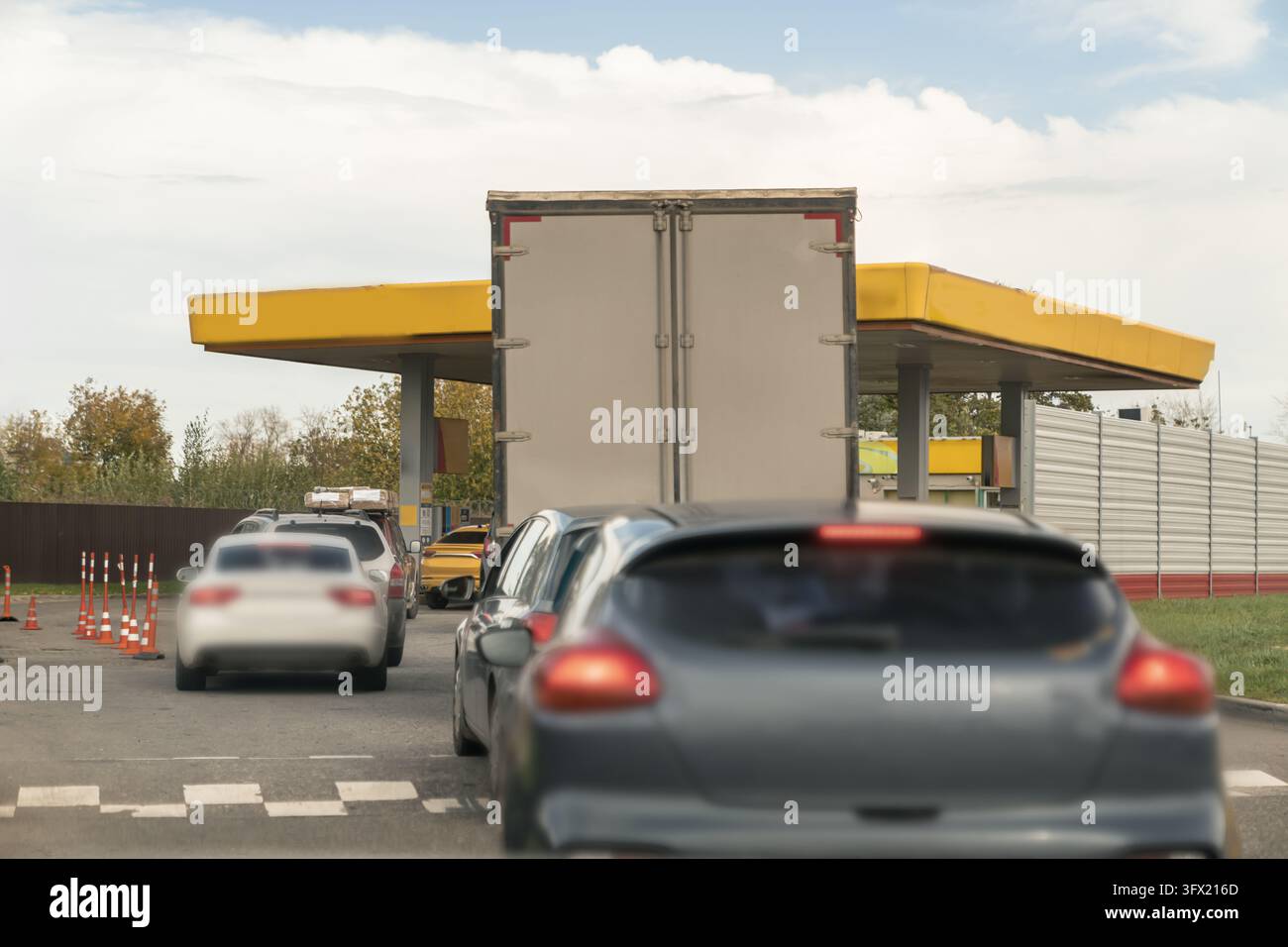 Personenkraftwagen und ein Lieferwagen warten in einer Schlange an einer Tankstelle. Konzeptdarstellung von Benzin- und Dieselknappheit, nicht verfügbarem Kraftstoff, Nachschub Stockfoto
