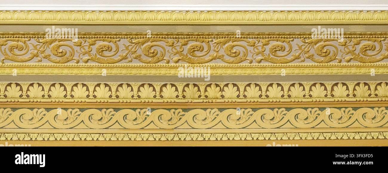 Goldener ornamentaler Fries mit kunstvollen klassischen Mustern und dekorativen architektonischen Elementen Stockfoto