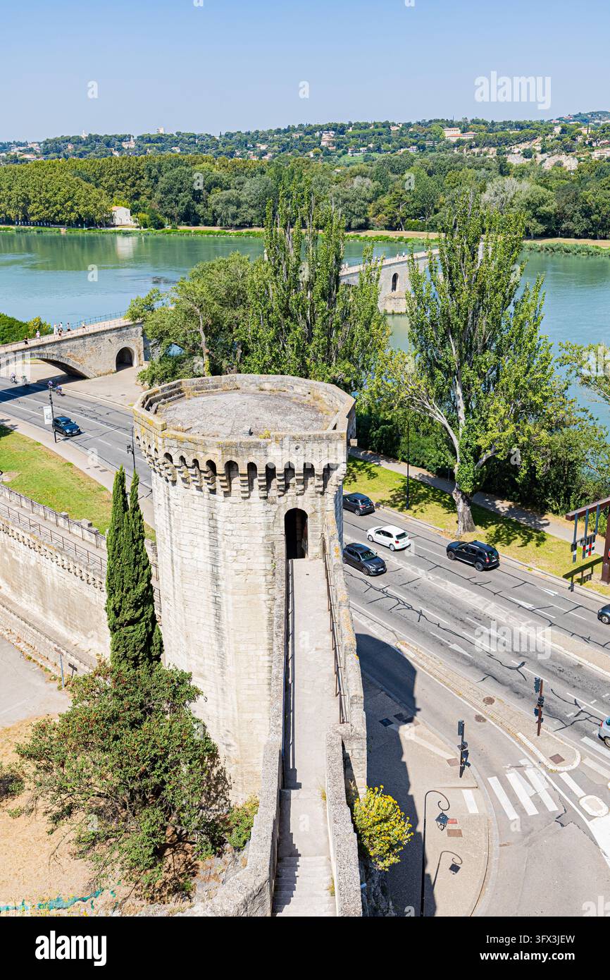 Erhöhte Ansicht eines Steinturms, einer Brücke, die einen Fluss überquert, einer Straße und von Bäumen gesäumten Flussufern in Avignon, Frankreich. Stockfoto