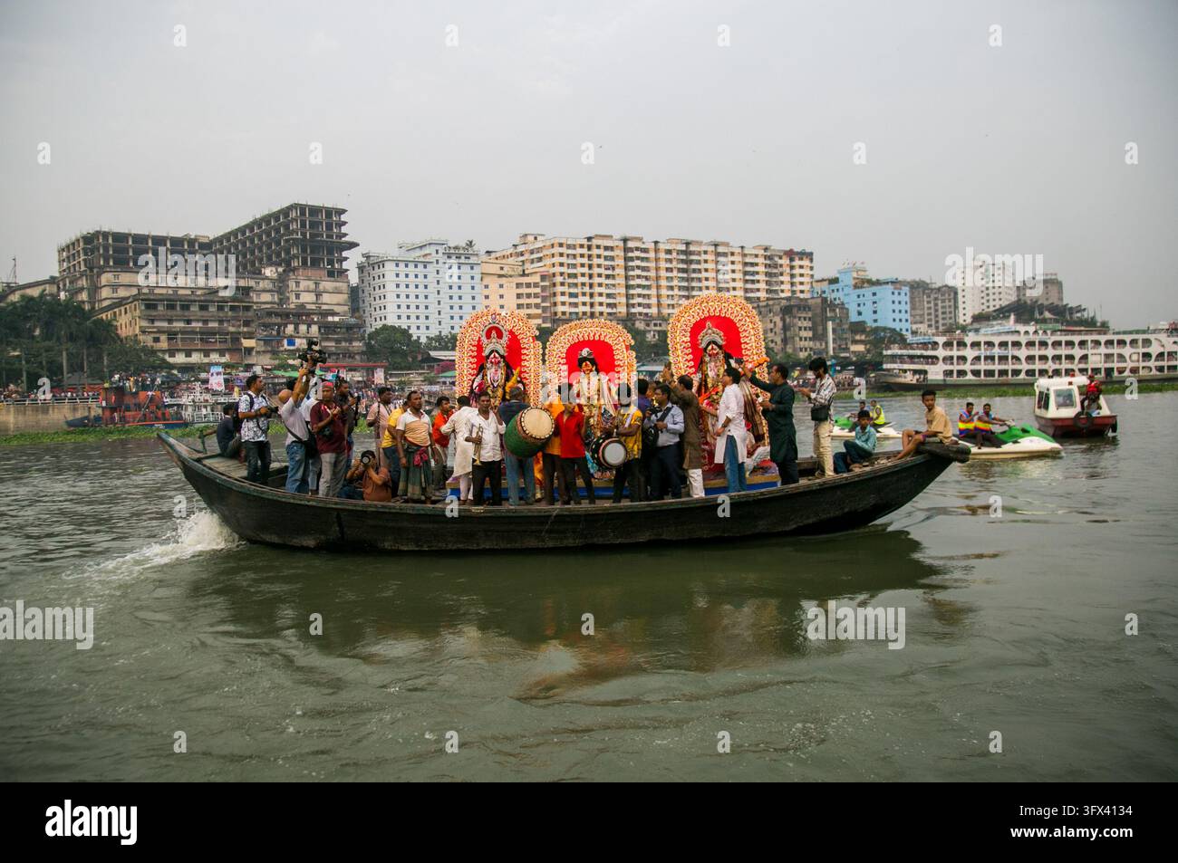 21. Oktober 2026 - Dhaka, Bangladesch: Die historischen Gassen des alten Dhaka erwachten mit Musik, Tanz und Gebeten zum Leben, als hinduistische Gläubige den letzten Tag des Durga Puja feierten, der mit der Ein immersion (Bisorjon) der Göttinnenstatuen von Durga im Buriganga-Fluss gipfelte. Der Tag begann in Nachbartempeln (mandap), wo junge Trommler traditionelle Dhak spielten und Frauen rituelle Abschiedsgebete sprachen. Als der Abend näher rückte, zogen farbenfrohe Straßenumzüge durch enge historischen Gassen, bei denen traditionelle Dhunuchi-Tänze mit brennenden Tonräuchergefäßen, orangefarbenen Rauchfackeln und singenden Menschenmassen zu sehen waren Stockfoto
