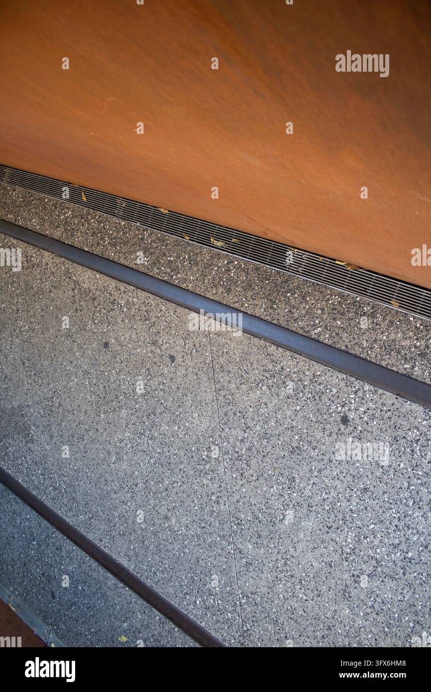 Ecke einer Gehwegmauer aus Ziegelstein und Metall, Eisenbahngleis aus Beton Stockfoto