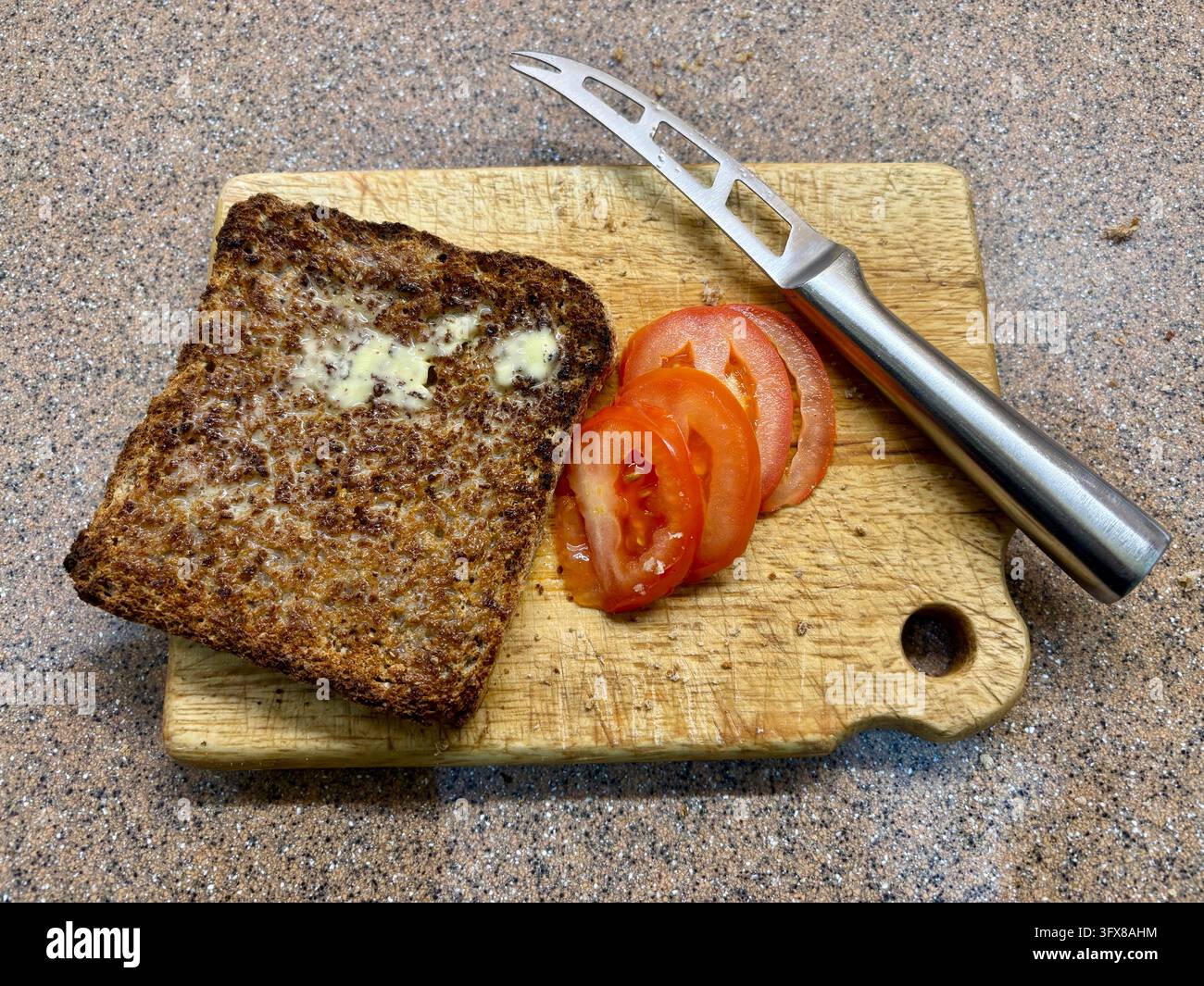 Gesundes Frühstück aus Vollkorntoast und frisch geschnittener Tomate. Stockfoto