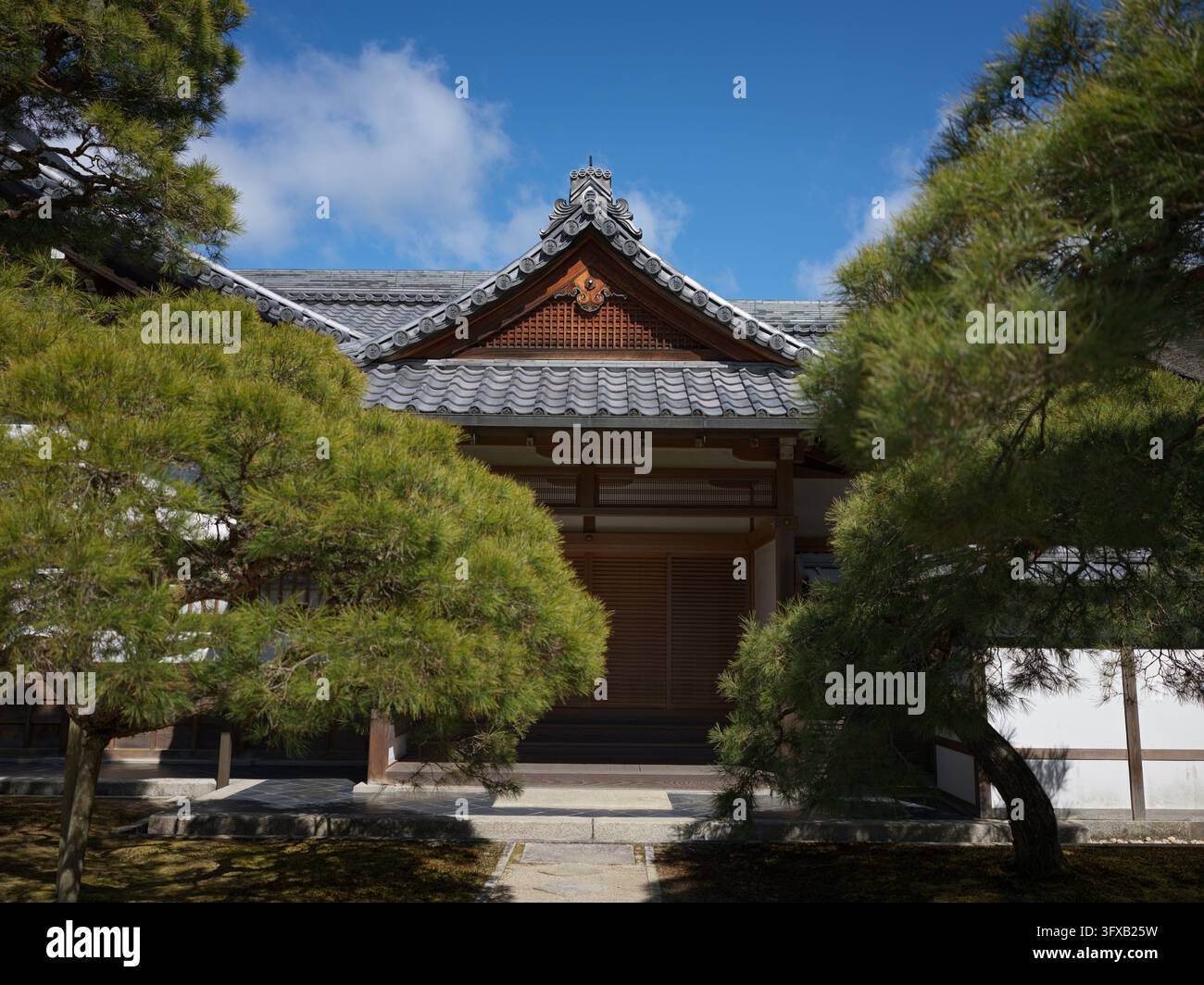 Tempel-Eingangsbereich mit einem Ziegeldach, eingerahmt von zwei Kiefern in Kyoto. Stockfoto
