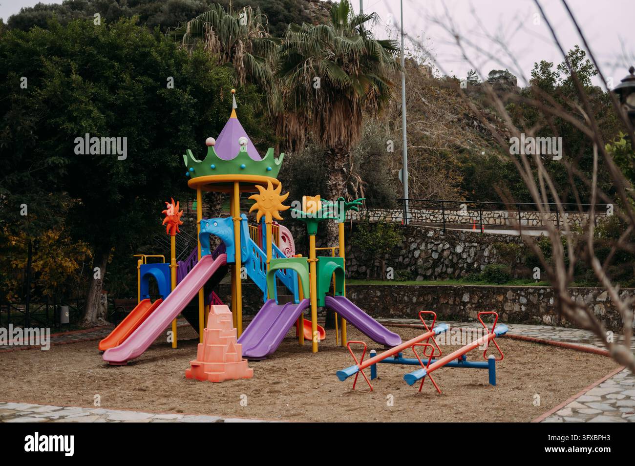Farbenfroher Freiluftspielplatz mit schlossthematischen Rutschen und Wippen Stockfoto