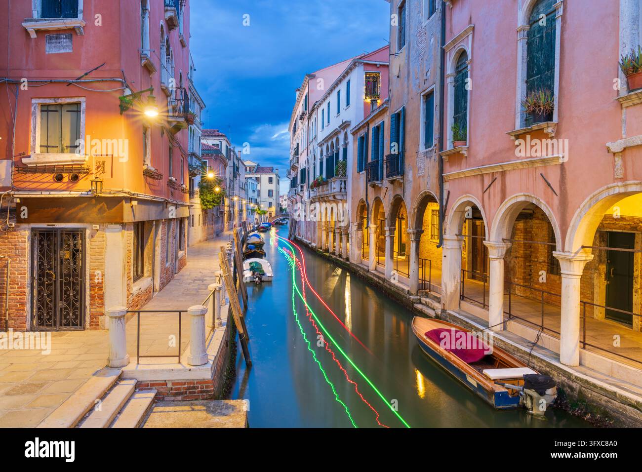 Venedig, Italien am Rio di San Felice mit Lichtspuren von einem vorbeifahrenden Motorboot zur Blauen Stunde. Stockfoto