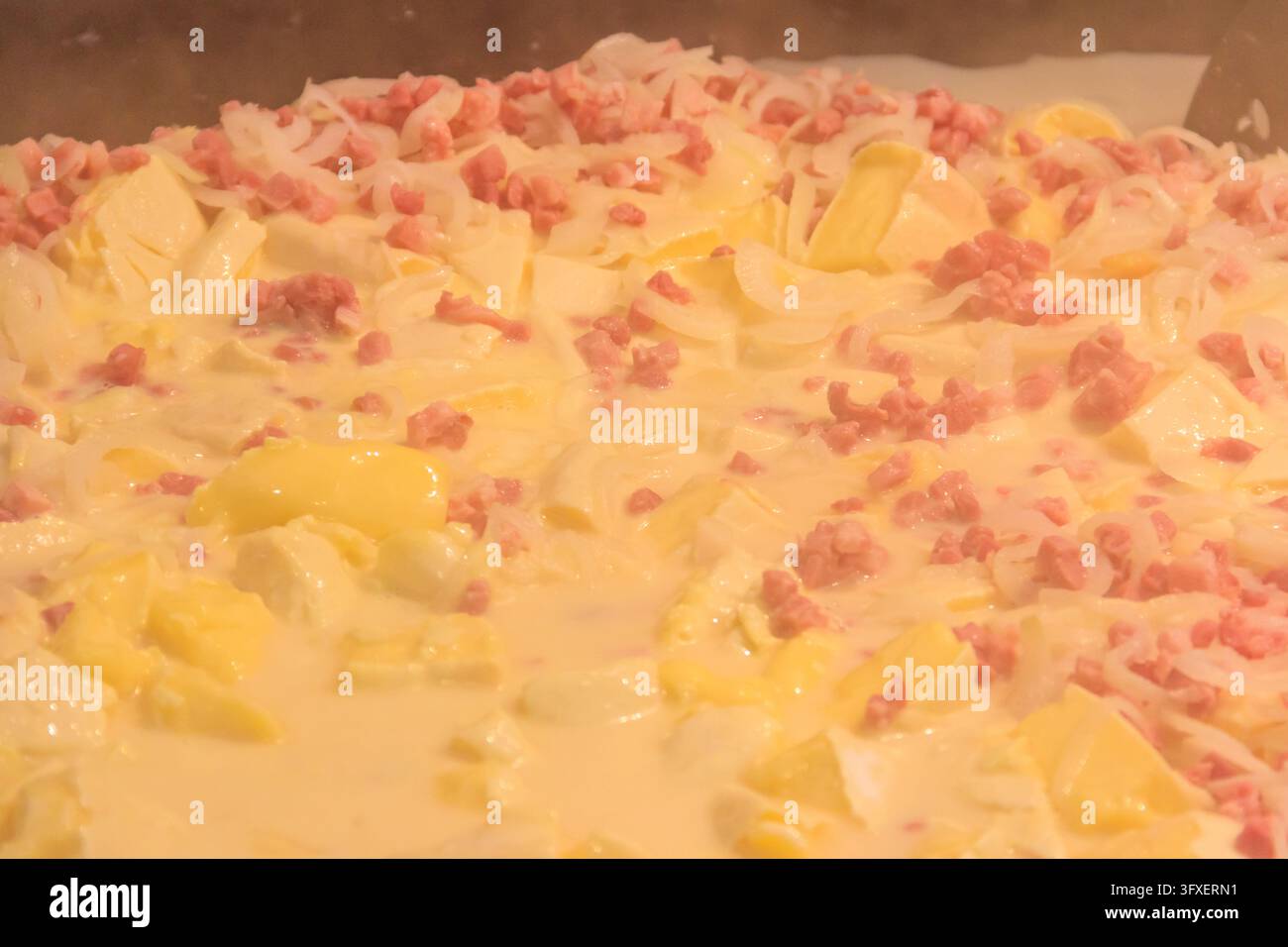 Zubereitung von Tartiflette, ein traditionelles französisches Gericht mit Jakobskartoffeln, Speck und Käse, in großem Kessel Stockfoto