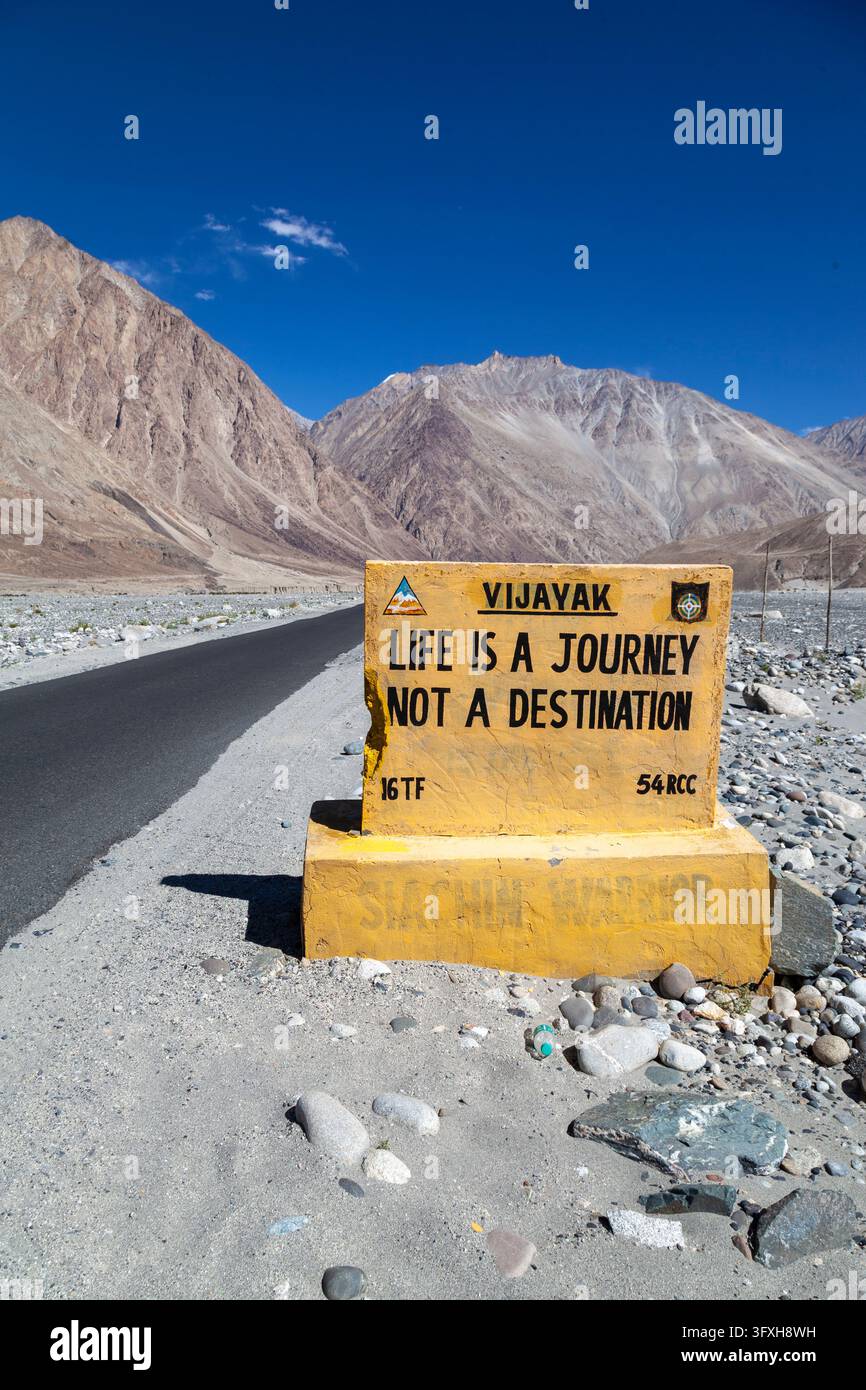 Gelbes Straßenschild neben einer Asphaltstraße in einem Hochtal in Ladakh, Turtuk, Indien Stockfoto