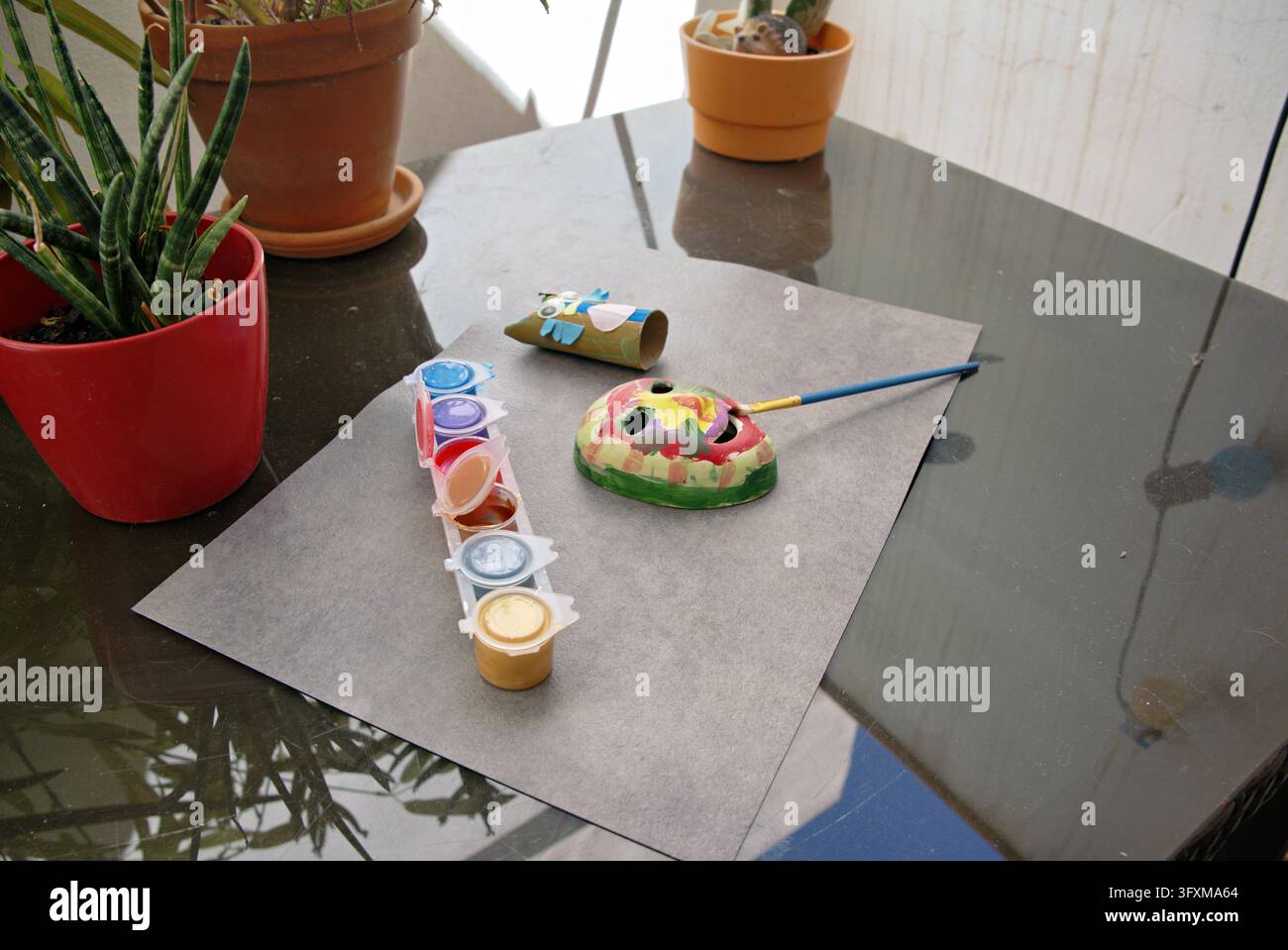 Malerhandwerkprojekt mit Maskenpinsel und Farbtöpfen auf dem Tisch Stockfoto