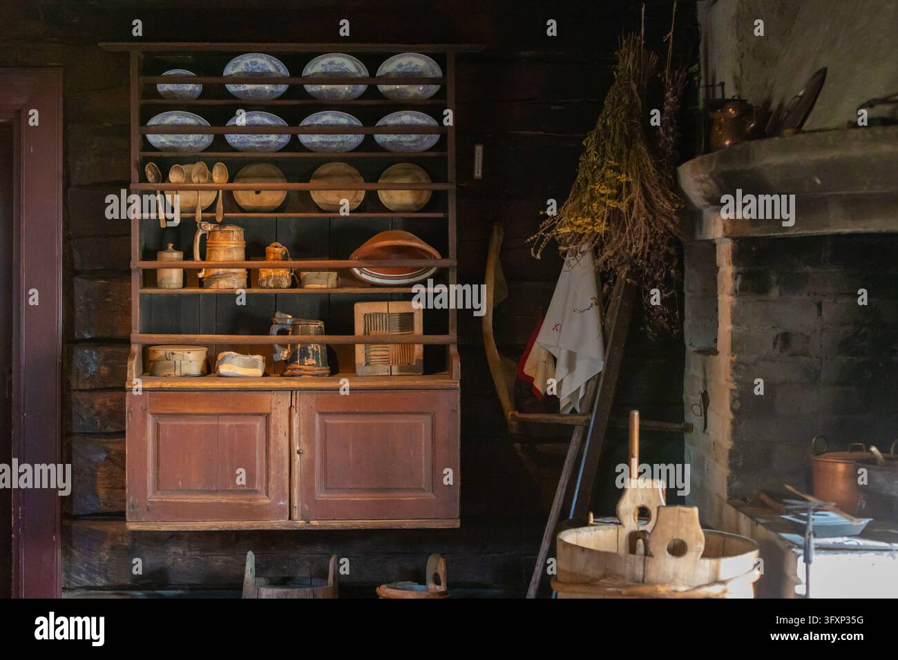 Espoo, Finnland - Oktober 20, 2026: Innenansicht des Glims Farmstead Museums mit einem rustikalen Holzschrank, der an Blockhauswänden montiert ist und Vintage-C aufweist Stockfoto