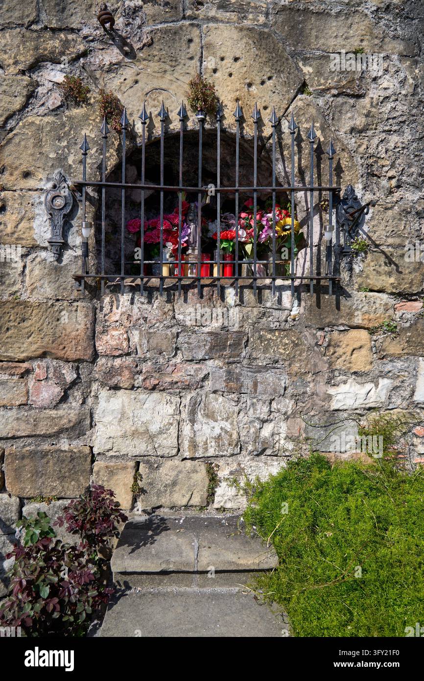 Geschmückter Wallfahrtsort mit einer Statue der Jungfrau Maria und Blumen in den Wänden bei der Puerta de Santa María, Hondarribia, Spanien Stockfoto