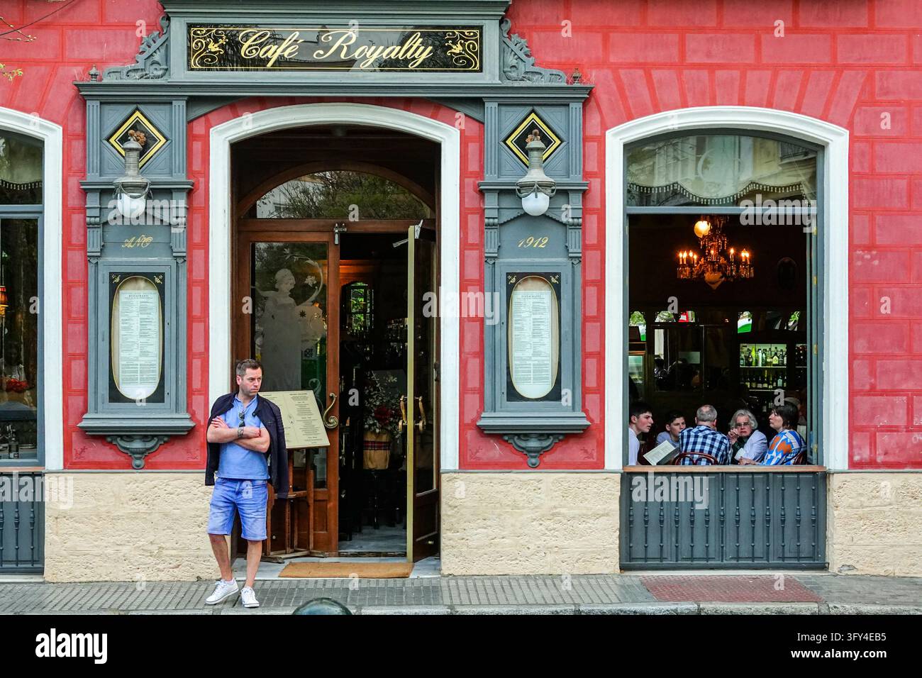 Ein Mann wartet vor dem Café Royalty, das 1912 anlässlich des hundertjährigen Jubiläums der Verfassung von Cádiz von 1812 eröffnet wurde, in Cádiz, Spanien. Stockfoto