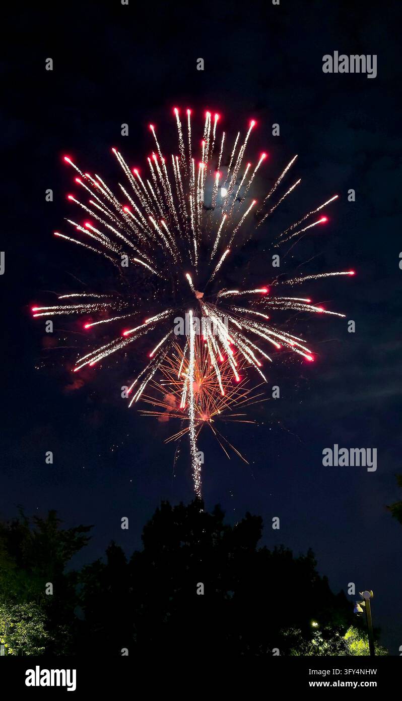 Feuerwerksshow zum Vierten von Juli erhellt den Nachthimmel während der Feiern zum US-Unabhängigkeitstag - Smartphone-aufgenommenes Stockfoto