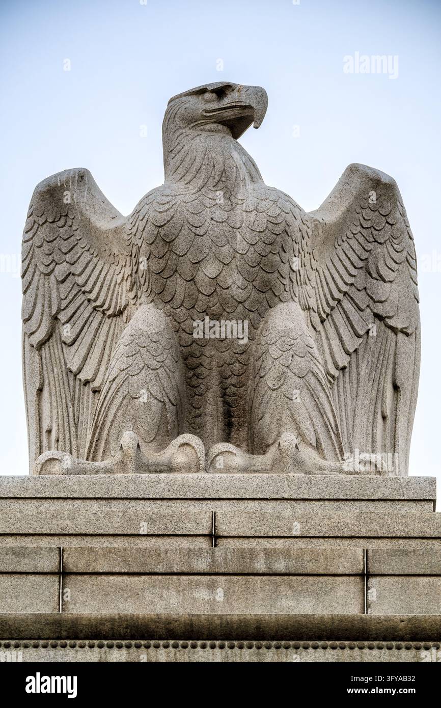 Adler aus Granit auf Pylone am Memorial Circle in Washington DC | WASHINGTON — Ein Adler aus Granit mit halb gehobenen Flügeln steht auf seinem Stufen-Gesteinsblock oben auf einem Pylone am Memorial Circle auf Columbia Island in Washington, D.C., am Freitag, den 23. Oktober 2026. Carl Paul Jennewein modellierte den Adler, einen von vier, die von Grenci & Ellis aus Peekskill, New York, unter einem am 22. April 1930 vergebenen Vertrag aus 30-Tonnen-Gesteinsblöcken vor Ort gemeißelt wurden. William Mitchell Kendall von McKim, Mead & White entwarf die Pylone, die 1929 an den Enden der Arlington Memorial Bridge und der Boundary Channel Bridge gebaut wurden. Die Krallen des Adlers umklammern den Gesteinsblock Stockfoto