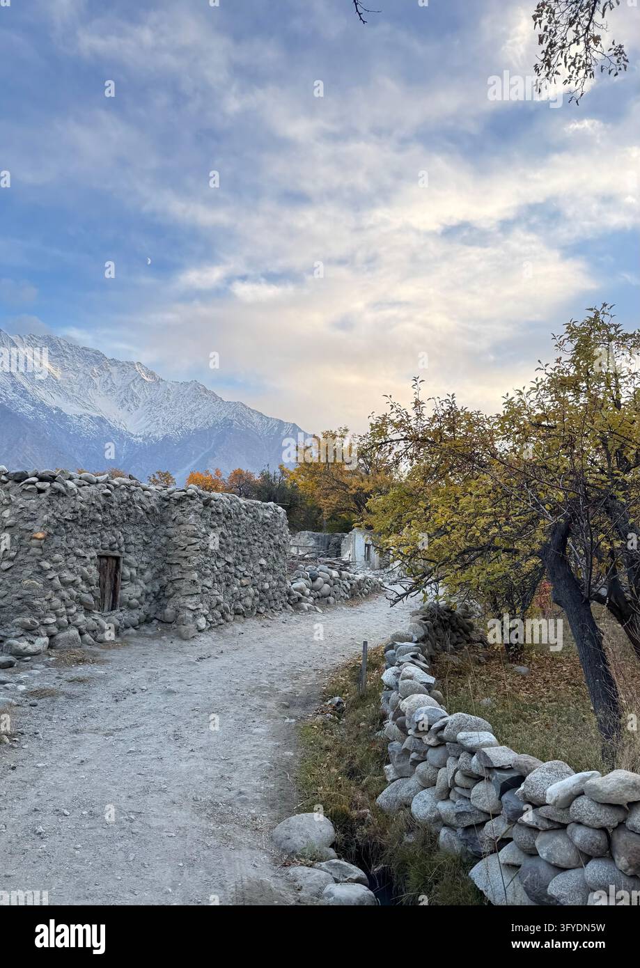 Bergdorfpfad mit Steinmauern und Bäumen Stockfoto