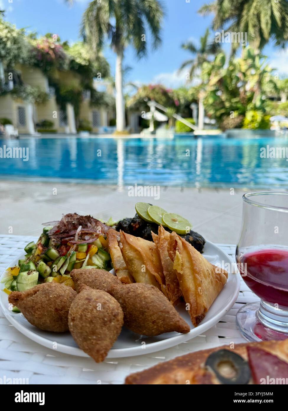 Mittleröstliches Mittagessen mit Kibbeh, Samosas und Salat an einem Hotel-Pool - Smartphone-aufgenommenes Stockfoto