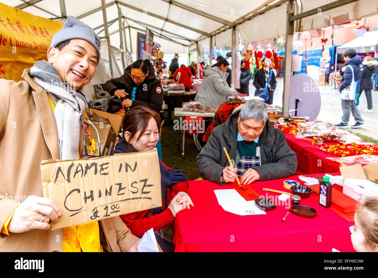 chinesischer asiatischer Mann hält ein Pappschild, "Name auf Chinesisch"-Stand während der Festveranstaltung Newcastle upon Tyne, UK Chinesischer Neujahrsumzug Stockfoto
