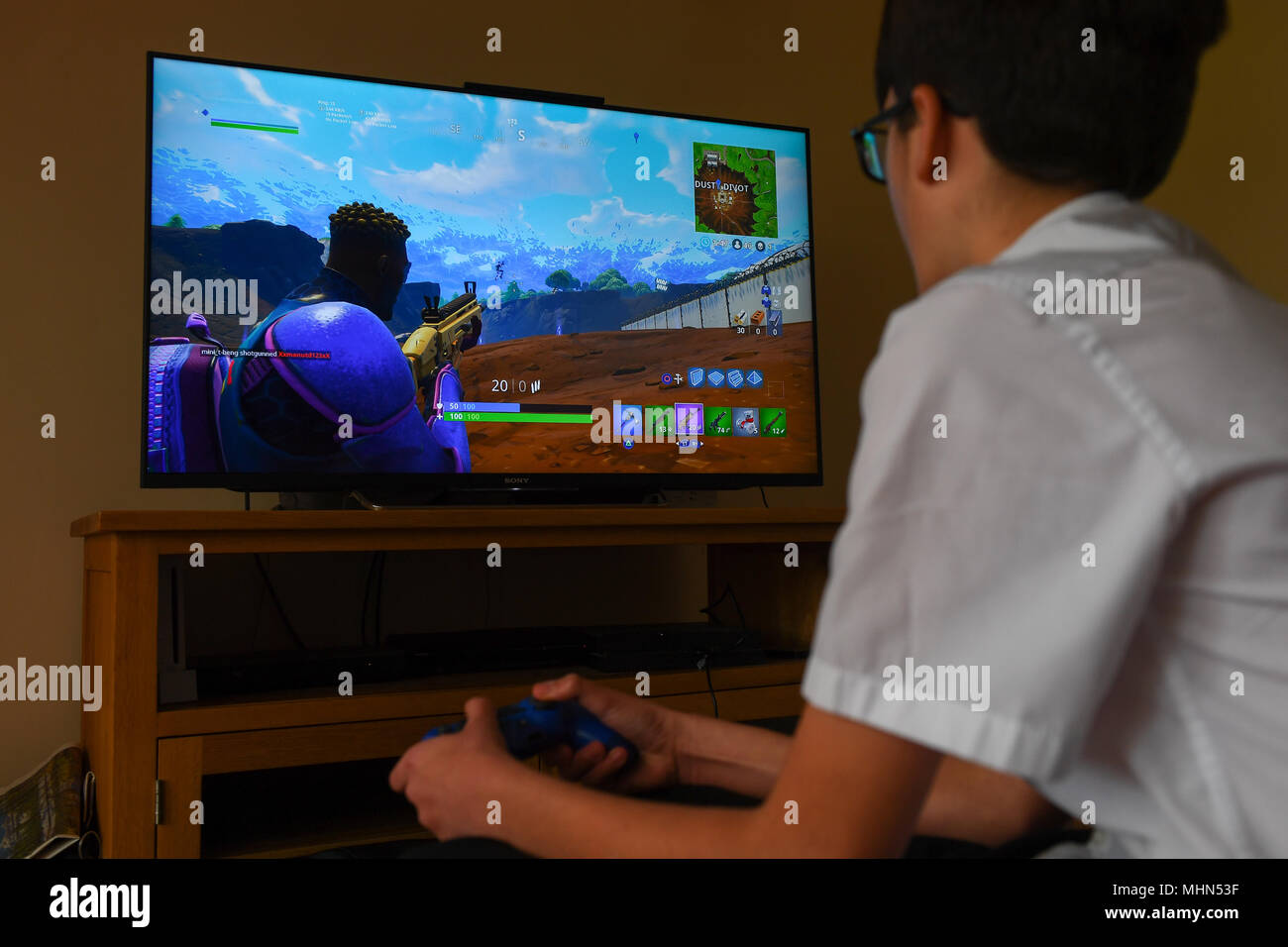 Ein Teenager Boy Spielt Die Hit Computer Spiel Fortnite Auf Einem - ein teenager boy spielt die hit computer spiel fortnite auf einem grossen tv auf einer playstation 4 konsole