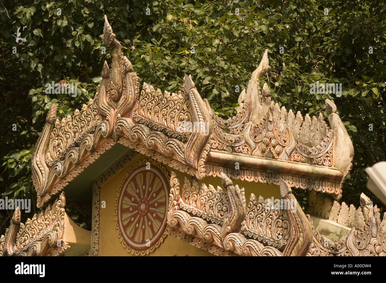 Komplizierte Schnitzereien auf dem goldenen birmanischen Tempeldach in Sarnath, Varanasi, Uttar Pradesh, Indien. Verzierte buddhistische Architekturdetails. Stockfoto
